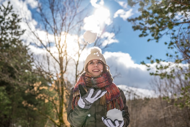 Retrato Mulher bonita jovem curtindo e brincando com neve no inverno