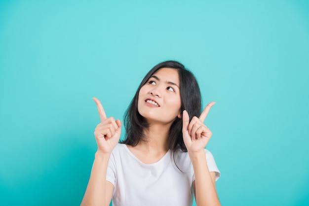 Foto retrato mulher jovem e bonita asiática em pé e apontando o dedo