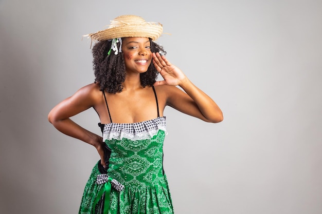 Retrato mulher negra brasileira em roupas de festa junina festival de São João gritando anunciando em voz alta