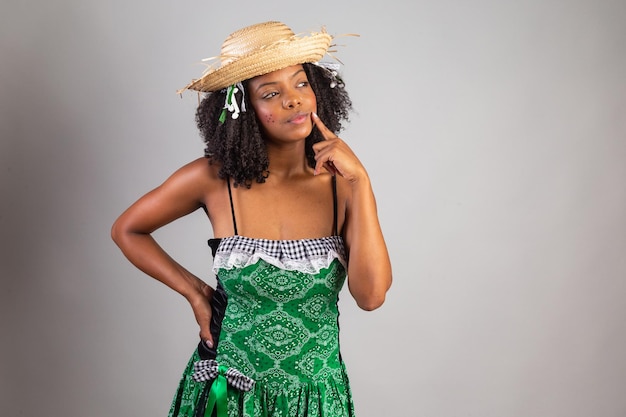 Retrato Mulher negra brasileira em roupas de festa junina pensando no festival de São João