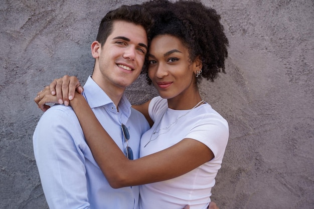 Retrato, de, un, multirracial, pareja joven, se abrazar, tiernamente, contra, un, concreto, wal