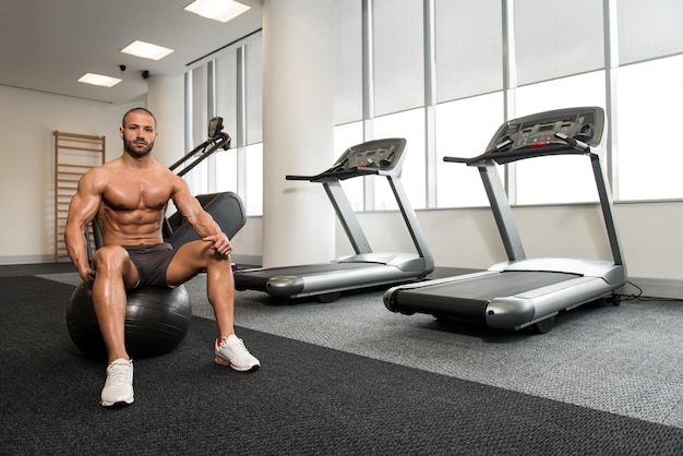 retrato, de, un, musculoso, hombre, descansar, en, pilates, pelota, en, gimnasio