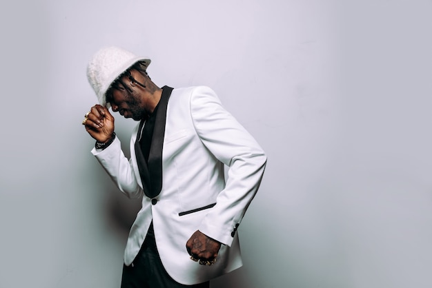 Retrato de un músico de música hip hop Imagen cinematográfica de un hombre vestido con ropa blanca y joyas