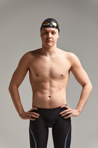 Foto retrato de un nadador con una gorra y una máscara retrato a mitad de longitud de un joven nadador atleta con un gorro y una gorra