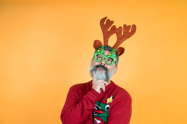 Foto retrato de navidad de hombre pensativo hipster mirando cuernos de ciervo.