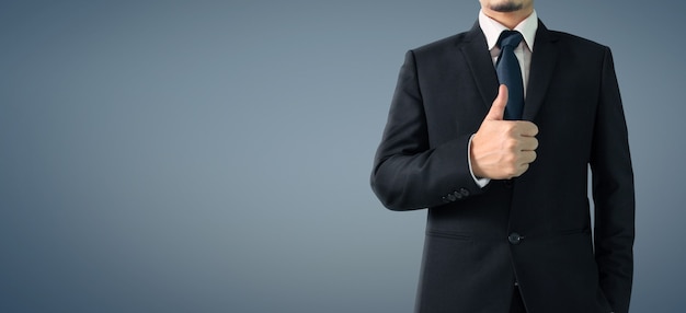 Retrato de negocios de hombre guapo en traje negro muestra ok