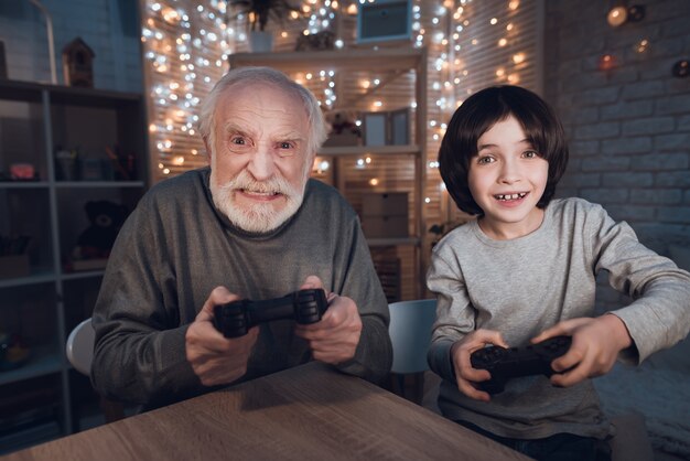 Retrato nieto jugar videojuego con el abuelo