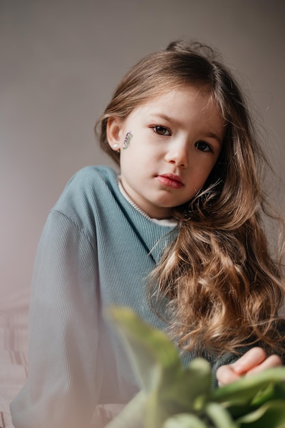 Retrato de una niña de 4 años sosteniendo un ramo de tulipanes rosados frescos posando para una foto con luz matutina