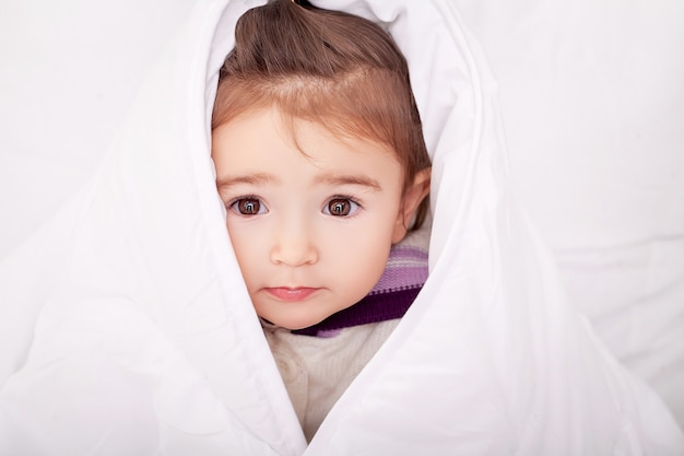 Retrato de niña acostada en una cama