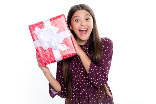 Retrato de niña adolescente emocionada asombrada emocionalmente Niño adolescente sorprendido sosteniendo caja de regalo sobre fondo blanco aislado Regalo para niños cumpleaños Caja de regalo de Navidad o Año Nuevo