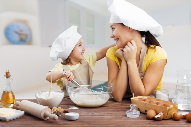 Retrato de niña adorable y su madre horneando juntos