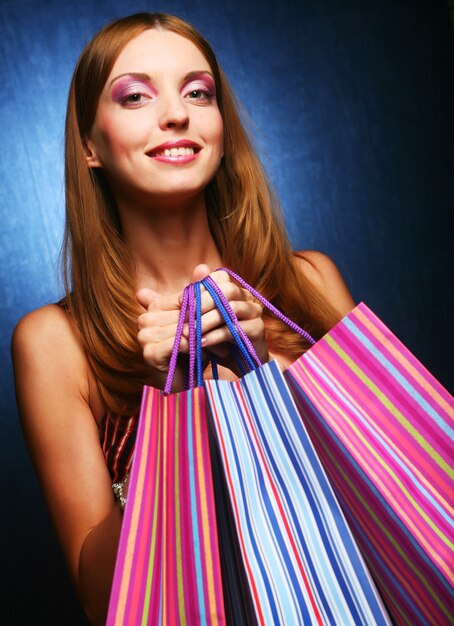 Retrato de una niña adulta joven feliz con bolsas de colores