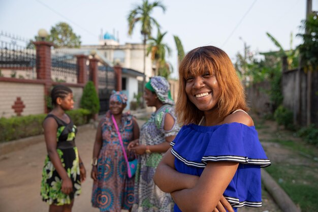 Retrato de una niña africana aislada con otras tres mujeres en el fondo hablando entre sí concepto de mujeres en África