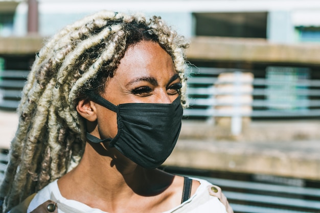 Retrato de niña africana con rastas rubias con máscara de protección facial