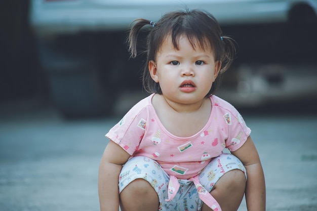 Retrato de una niña agachada en un sendero