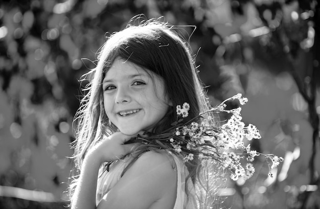 Retrato de niña al aire libre en el prado Niño lindo con flores en un jardín niños