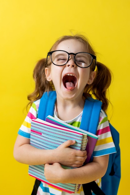 Retrato de una niña alegre escuchando música con auriculares blancos audiolibros lecciones de audio