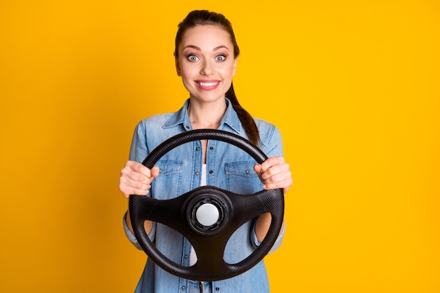 Retrato de niña alegre positiva disfrutar de la conducción de automóviles mantenga el volante desgaste estilo ropa elegante aislado sobre fondo de color brillante