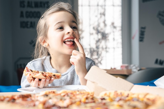 Retrato de una niña con un apetitoso trozo de pizza