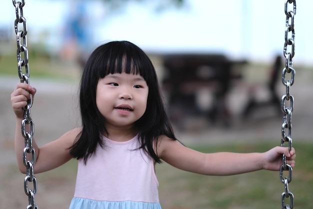 Retrato de una niña asiática en columpio