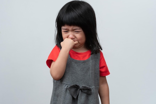 Retrato de una niña asiática enojada, triste y llorando sobre un fondo blanco aislado La emoción de un niño