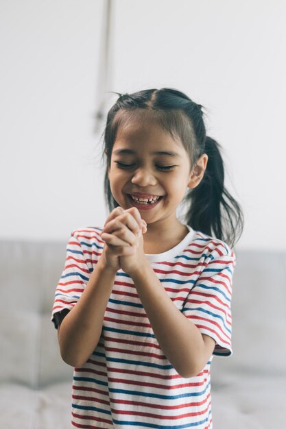 Retrato de una niña asiática feliz sonriendo y jugando en casa