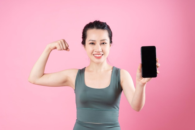 Retrato de niña asiática fitness, aislado sobre fondo rosa