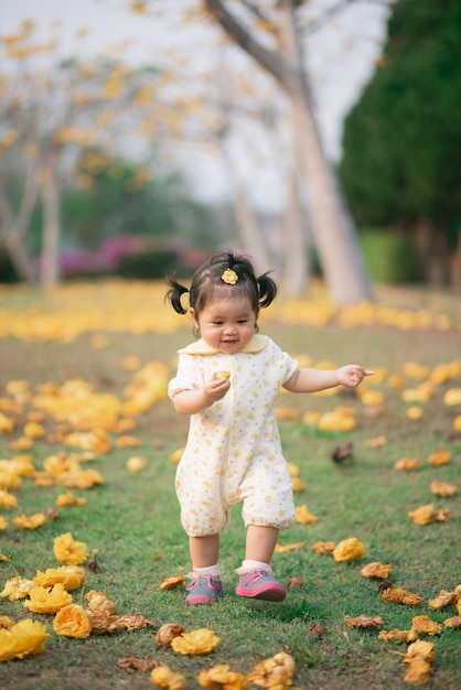 Retrato de niña asiática linda en el jardín de flores