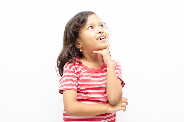 Retrato de niña asiática sonriente plantean gesto de pensamiento con expresión feliz