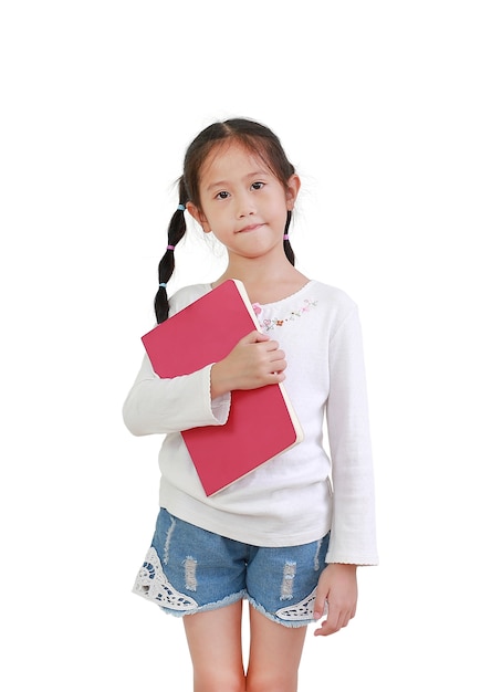 Retrato de niña asiática sonriente sostiene libro aislado en la pared blanca