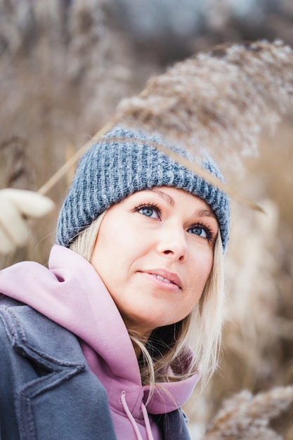 Retrato de una niña de aspecto europeo en un paseo de invierno, hierba, bosque, campo, sombrero, salud