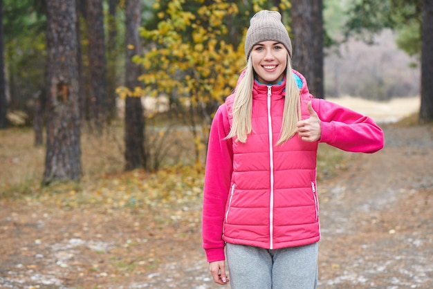 Retrato de una niña atletas en la chaqueta y gorra en el bosque. Un estilo de vida saludable