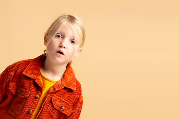 Retrato de una niña atractiva, emocionada y linda con la boca abierta mirando a la cámara