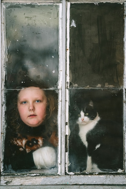 Retrato de niña auto aislada con cara aburrida y su adorable gatito