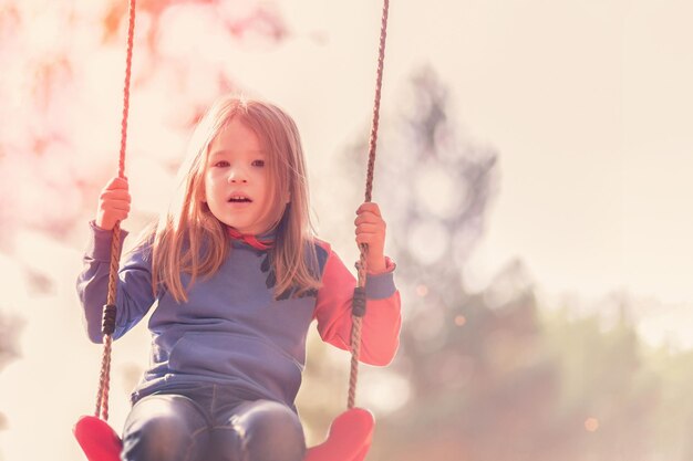 Retrato de niña balanceándose cerca