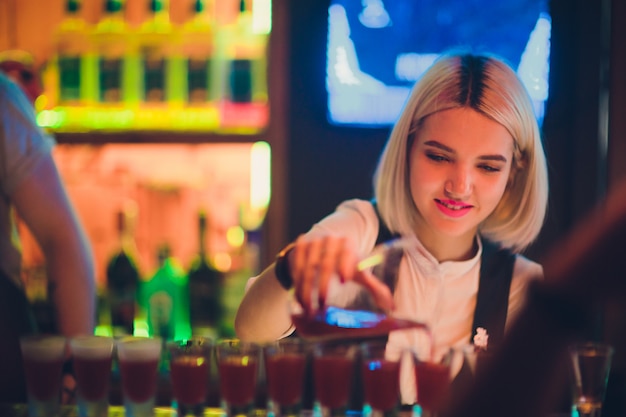 Retrato de una niña en un bar nocturno, detrás del mostrador.