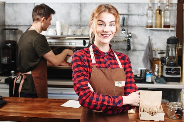 Retrato de una niña baristas en el lugar de trabajo sobre fondo de café