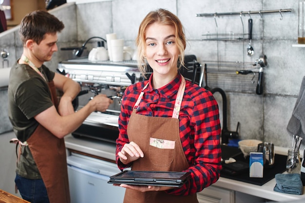 Retrato de una niña baristas en el lugar de trabajo sobre fondo de café