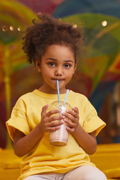 Retrato de niña bebiendo cócteles de leche de pajita