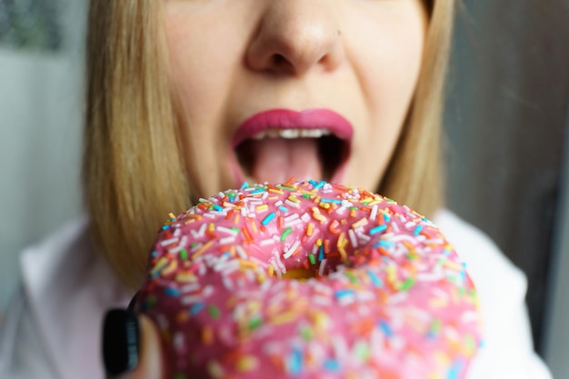 Retrato niña bonita comiendo donuts Joven caucásica comiendo donuts Enfoque selectivo