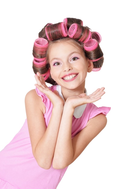 Retrato de niña bonita feliz en rizadores de pelo en estudio
