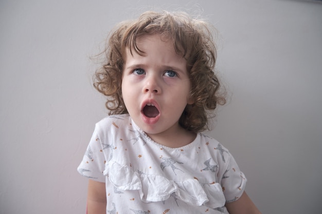 Retrato de una niña bonita haciendo expresión de asombro sorprendido en su rostro.