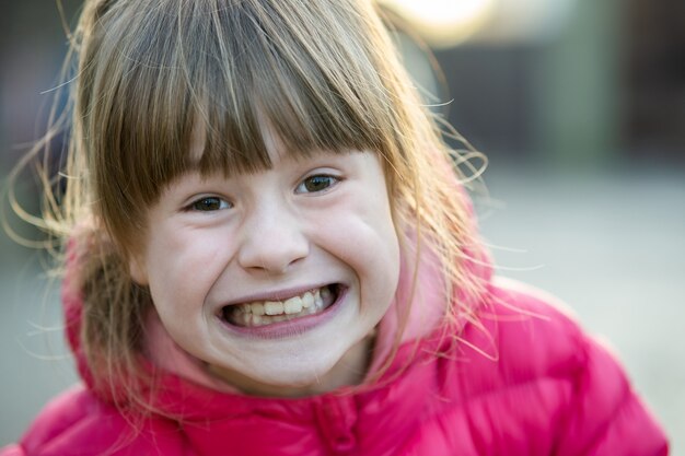 Retrato de una niña bonita niña al aire libre en un soleado día cálido de otoño.