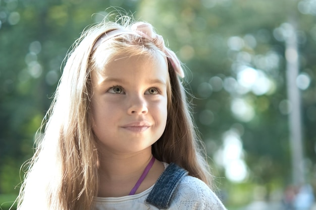 Retrato de niña bonita de pie al aire libre en el parque de verano.