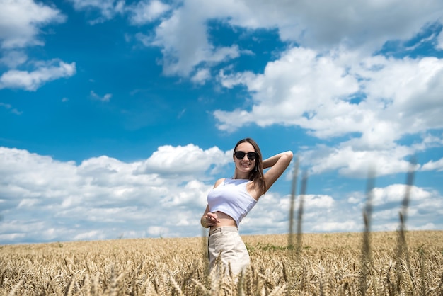 Retrato de niña bonita posando sobre fondo de un campo agrícola horario de verano