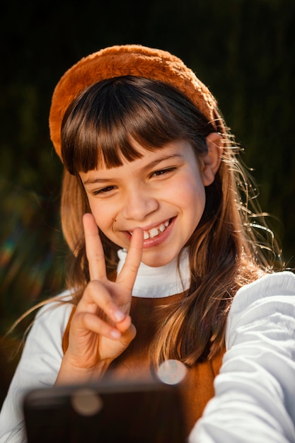 Retrato de niña bonita tomando un selfie