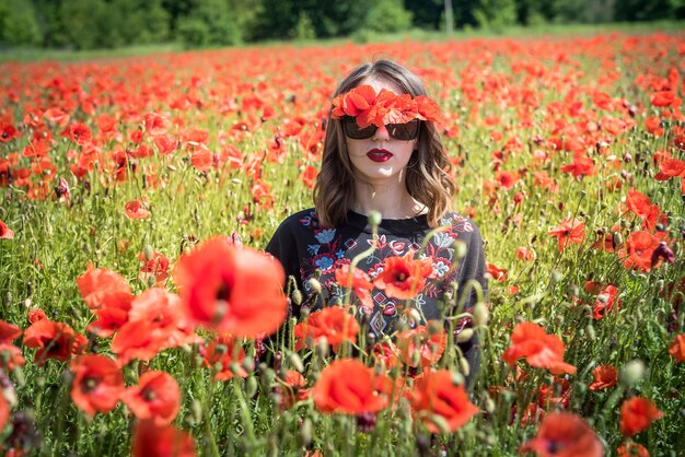 Retrato de niña en el campo de amapolas rojas. disfruta pasar tiempo en la naturaleza