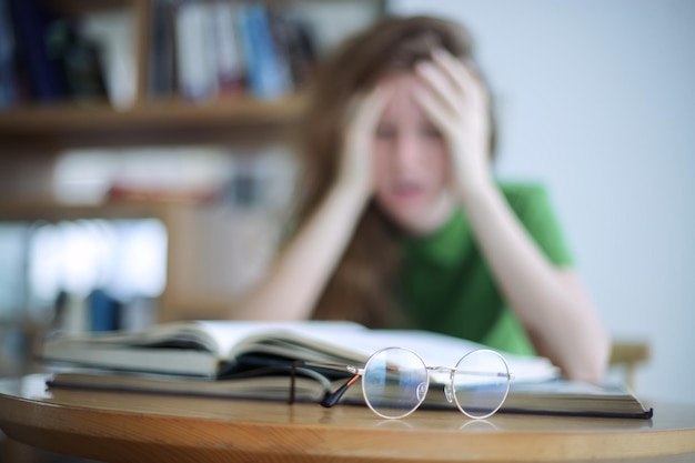 Retrato de niña cansada con exceso de trabajo agotada mujer joven en anteojos estudiante universitario o universitario es