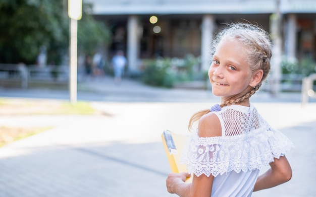 Retrato de una niña con una carpeta que va a la escuela