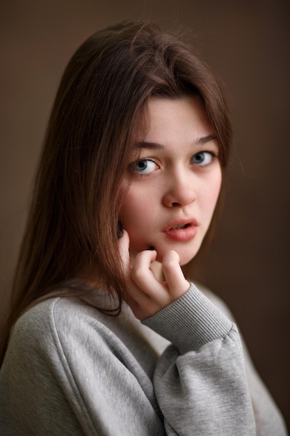 Retrato de una niña de cerca una niña sobre un fondo marrón una mirada hermosa